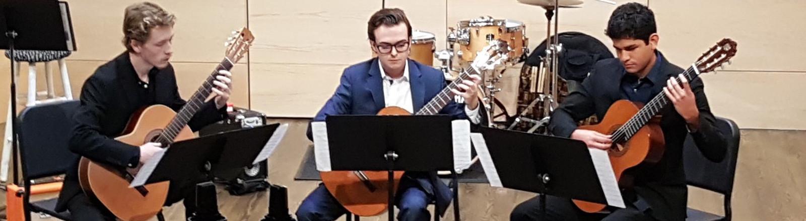Three Loyola School of Music student guitarists perform in Nunemaker Auditorium.