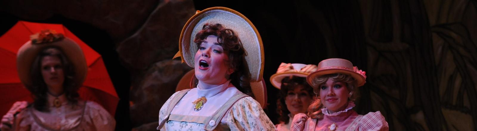Opera singer singing with characters in the background