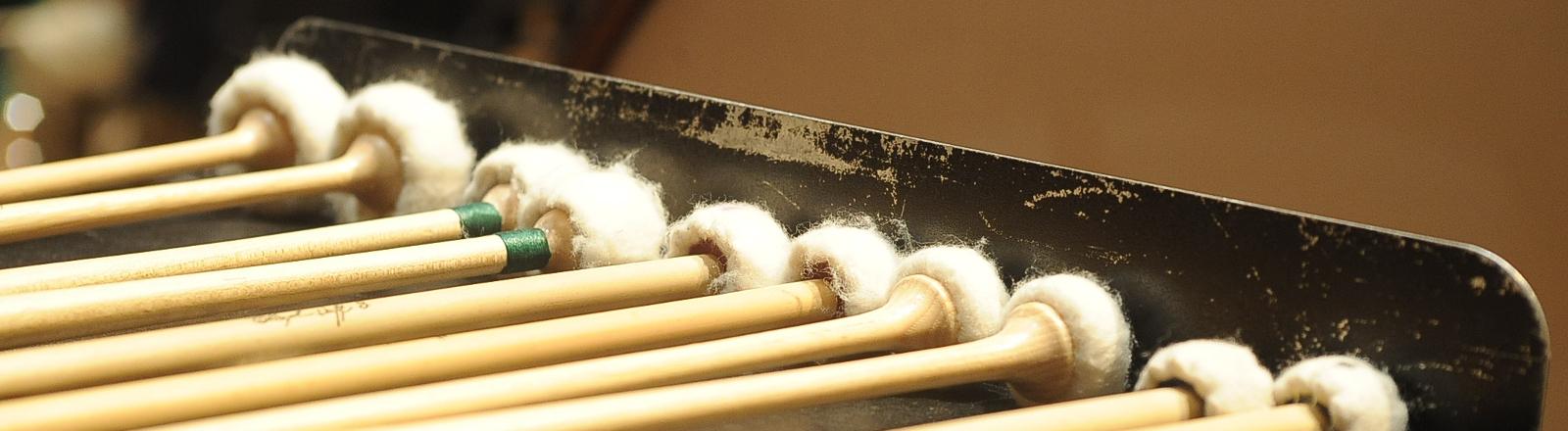 Percussion mallets lined up on a stand 